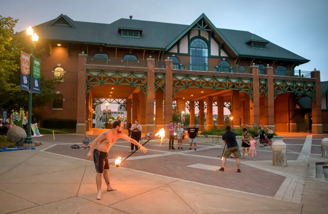 Brandon Wiesehan, foreground, of Peoria twirls a flaming staff as his fellow hula-hoopers and jugglers watch during a weekly gathering of the Heart of Illinois Hoopers at the Gateway Building on the Peoria riverfront.