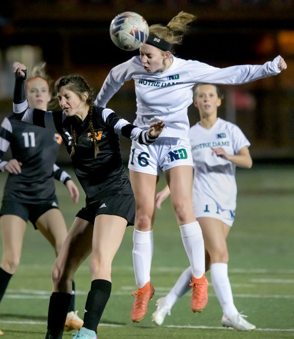 Peoria Notre Dame's Abigail Chaddock, right, heads the ball over Washington's Tori Aberle in the second period of their girls soccer match Tuesday, March 19, 2024 in Washington. The Irish defeated the Panthers 2-0.