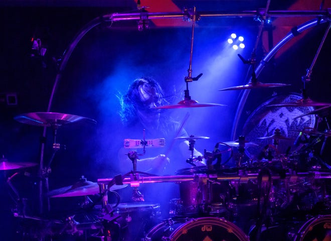 Queensrÿche drummer Casey Grillo pounds the drums under a blue light Wednesday, April 10, 2024 at the Peoria Civic Center Theater.