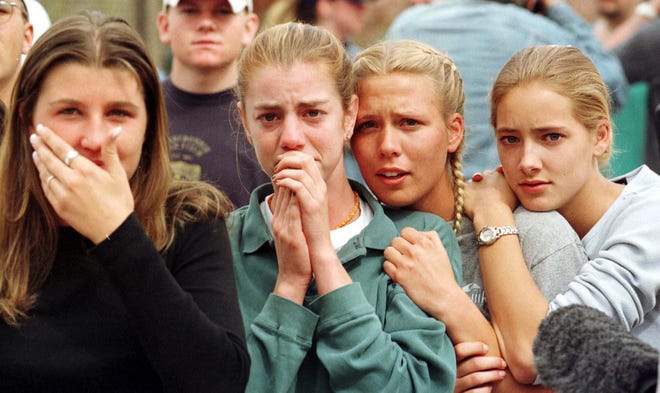 Students from Columbine High School in Littleton, Colo., watch as the last of their fellow students are evacuated from the school building on April 20, 1999, following a shooting spree at the school.