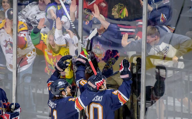 Peoria's JM Piotrowski and Jordan Ernst celebrate with fans through the glass after Piotrwoski's goal against Pensacola in the third period of Game 2 of the first round of the SPHL playoffs Saturday, April 13, 2024 at the Peoria Civic Center. The Rivermen advanced to the semifinals with a 6-1 victory.