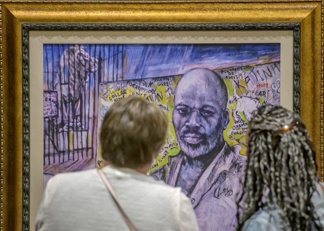 Deanna Littell, left, of Goodfield and Michele Mathes of Bloomington take a close look at an untitled oil painting by Peoria artist Preston Jackson during the "Change That Narrative" art show Saturday, April 13, 2024 at Four Points by Sheraton in downtown Peoria.