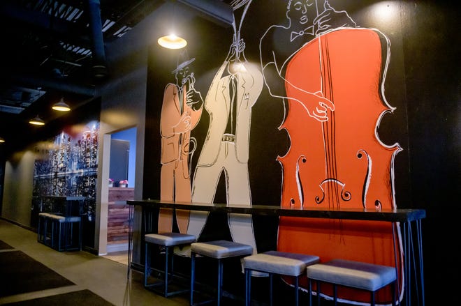 Fanciful paintings of stylish musicians cover a wall new the Jerk Hut restaurant inside the new club Empire Lounge in Peoria.